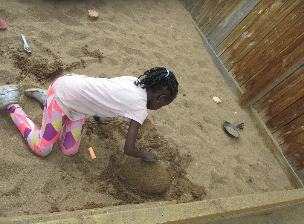 Child building in the sand pit